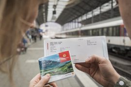 Turista verificando validade de bilhetes, essencial para planejar a compra do Swiss Travel Pass 2026.
